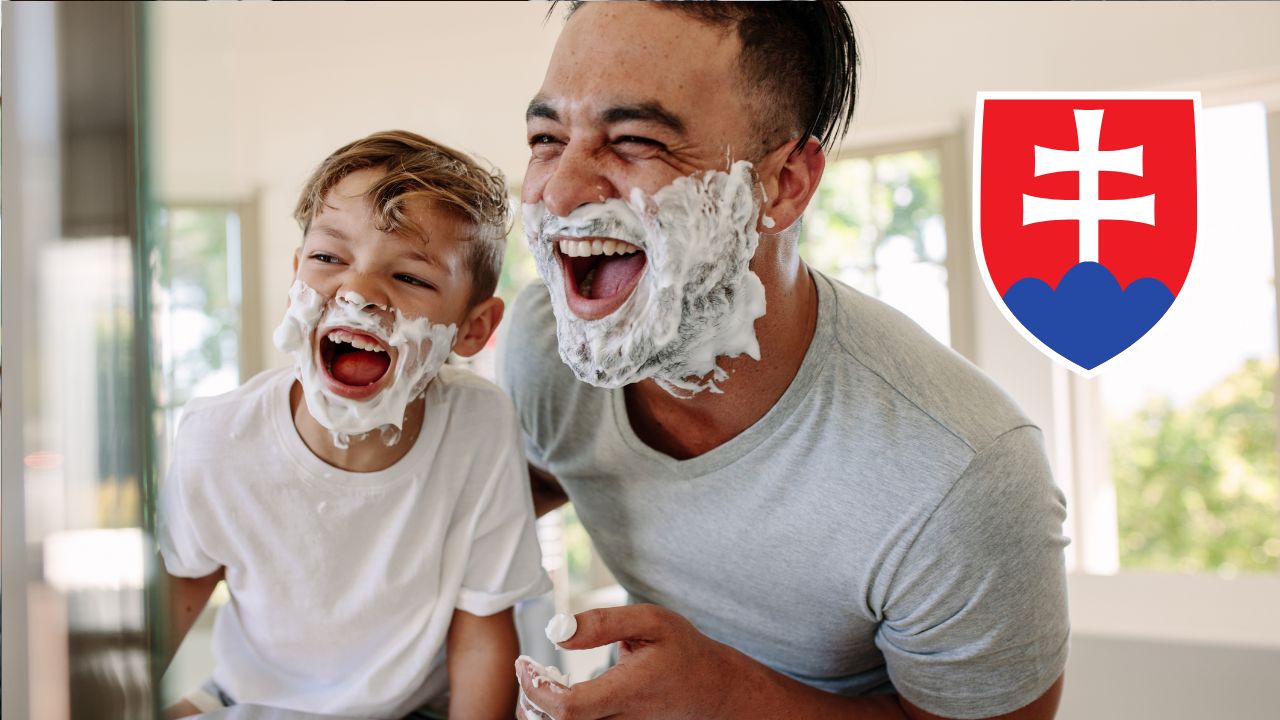 Otec a syn sa smejú s holiacou penou na tvári. Na obrázku je slovenský znak.