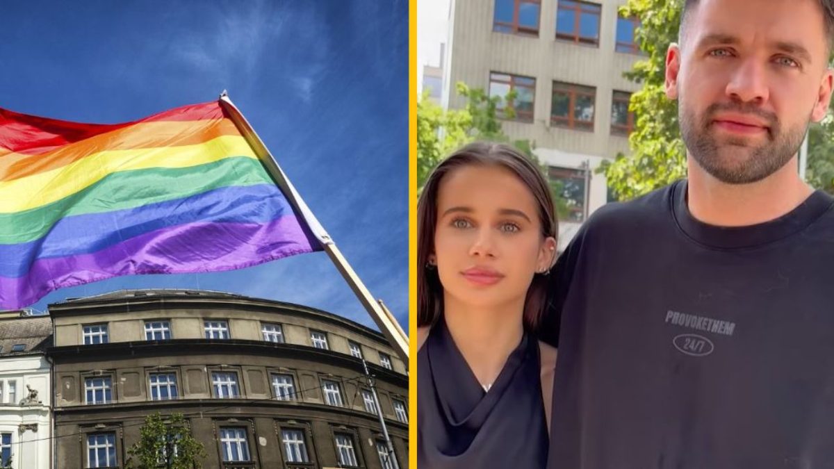 Dúhová vlajka nad budovou a mladý pár v meste za slnečného dňa.