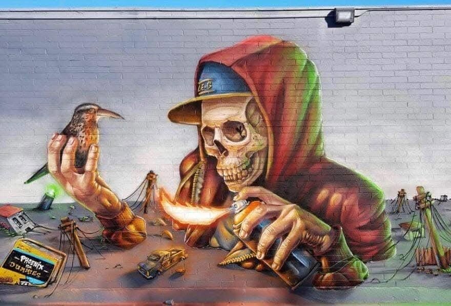 Graffiti lebky v červenej mikine s vtákom na ruke a sprejom v ruke na fialovej stene.