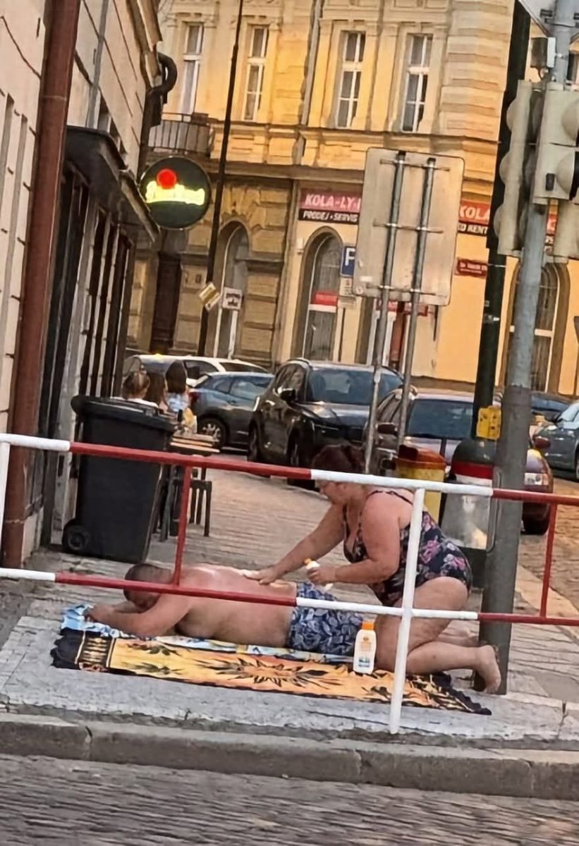 Ľudia oddychujúci na pláži v meste, relaxujúci na osuške s opaľovacím krémom, život v meste.