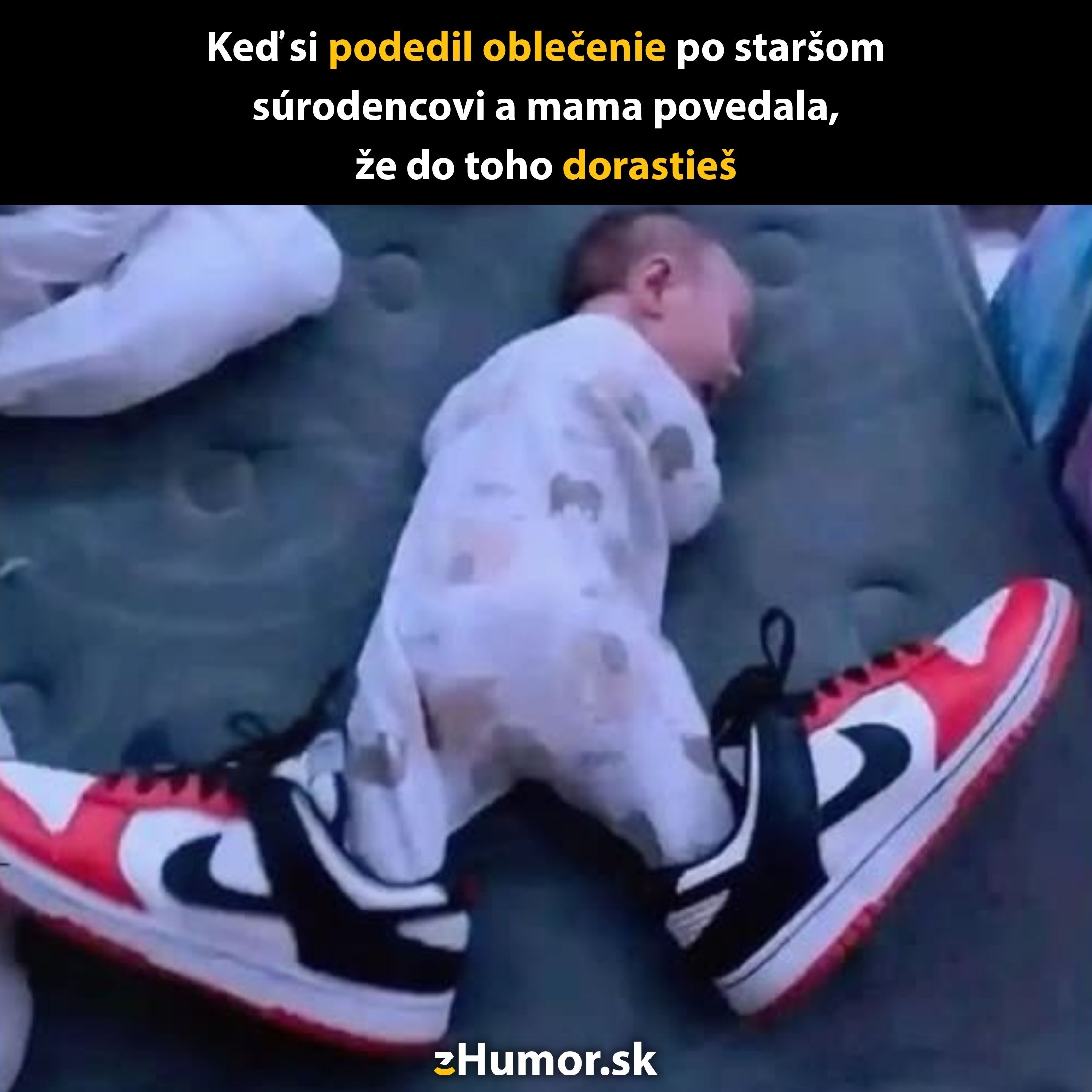 Dieťa v detskom overale leží s veľkými teniskami na nohách, vtipná situácia o dedení oblečenia.