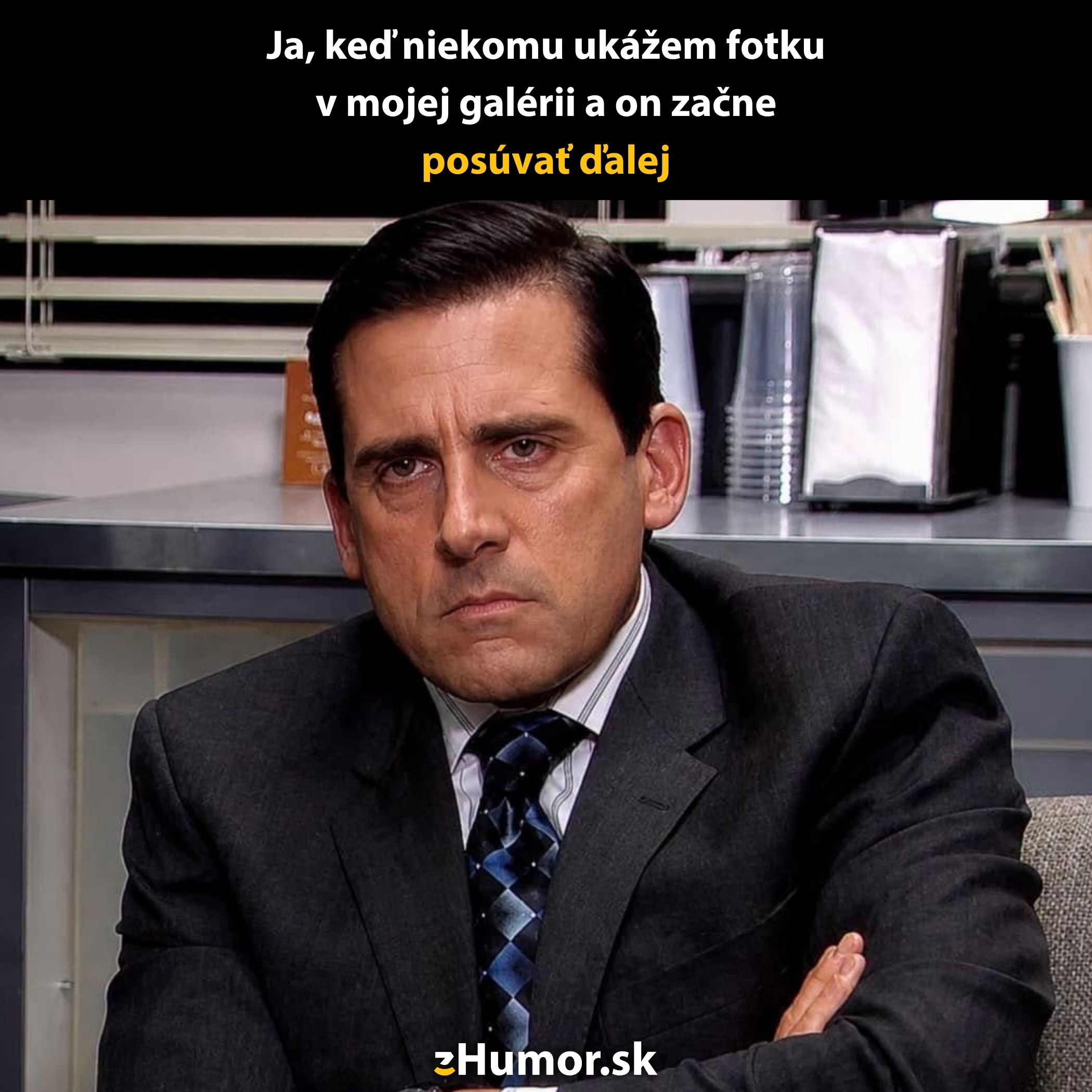 Muž v kancelárii s vážnym výrazom pri pohľade na niekoho, kto si prezerá jeho galériu fotografií.