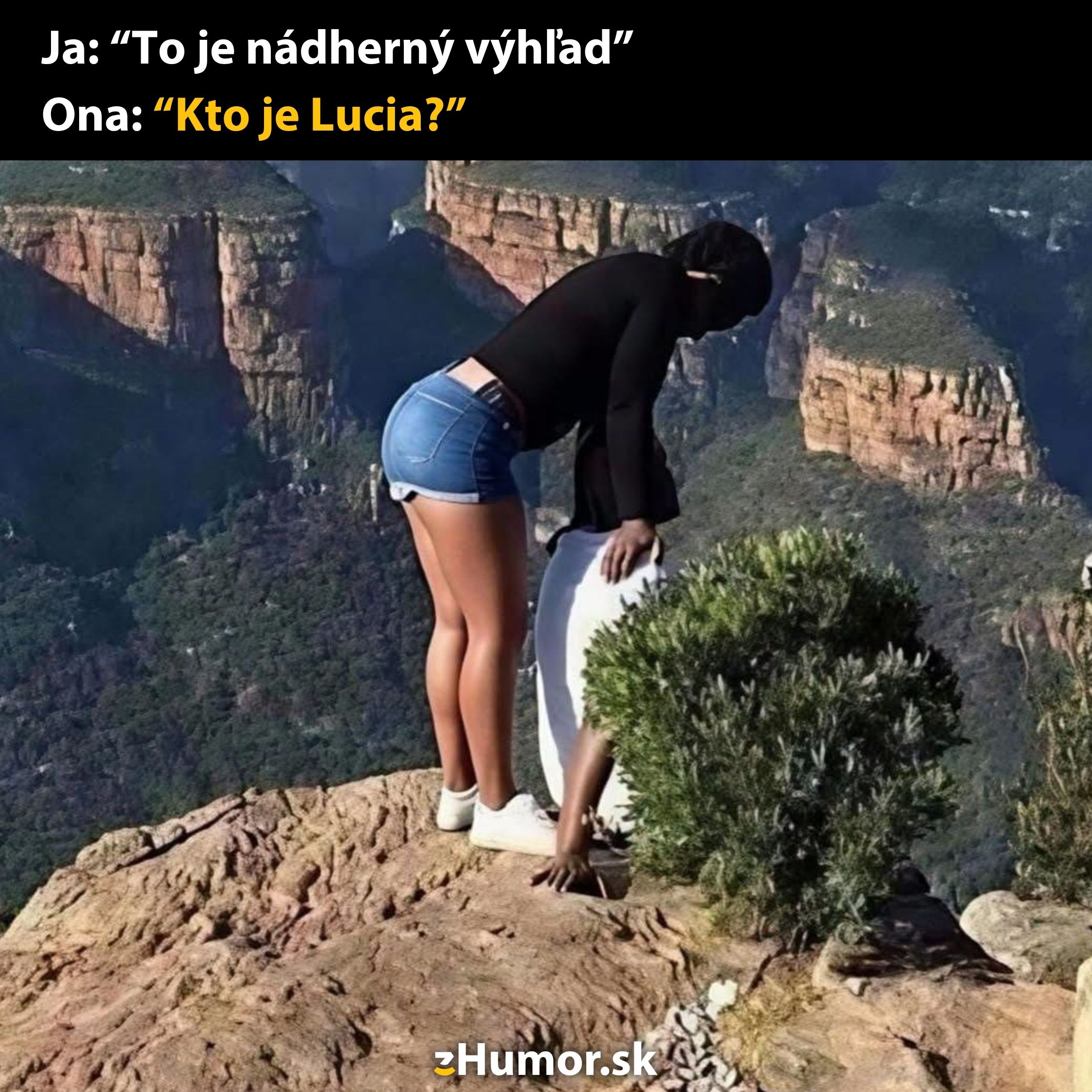 Dve osoby na útesu s vtipným textom o nádhernom výhľade a identity Lucie.