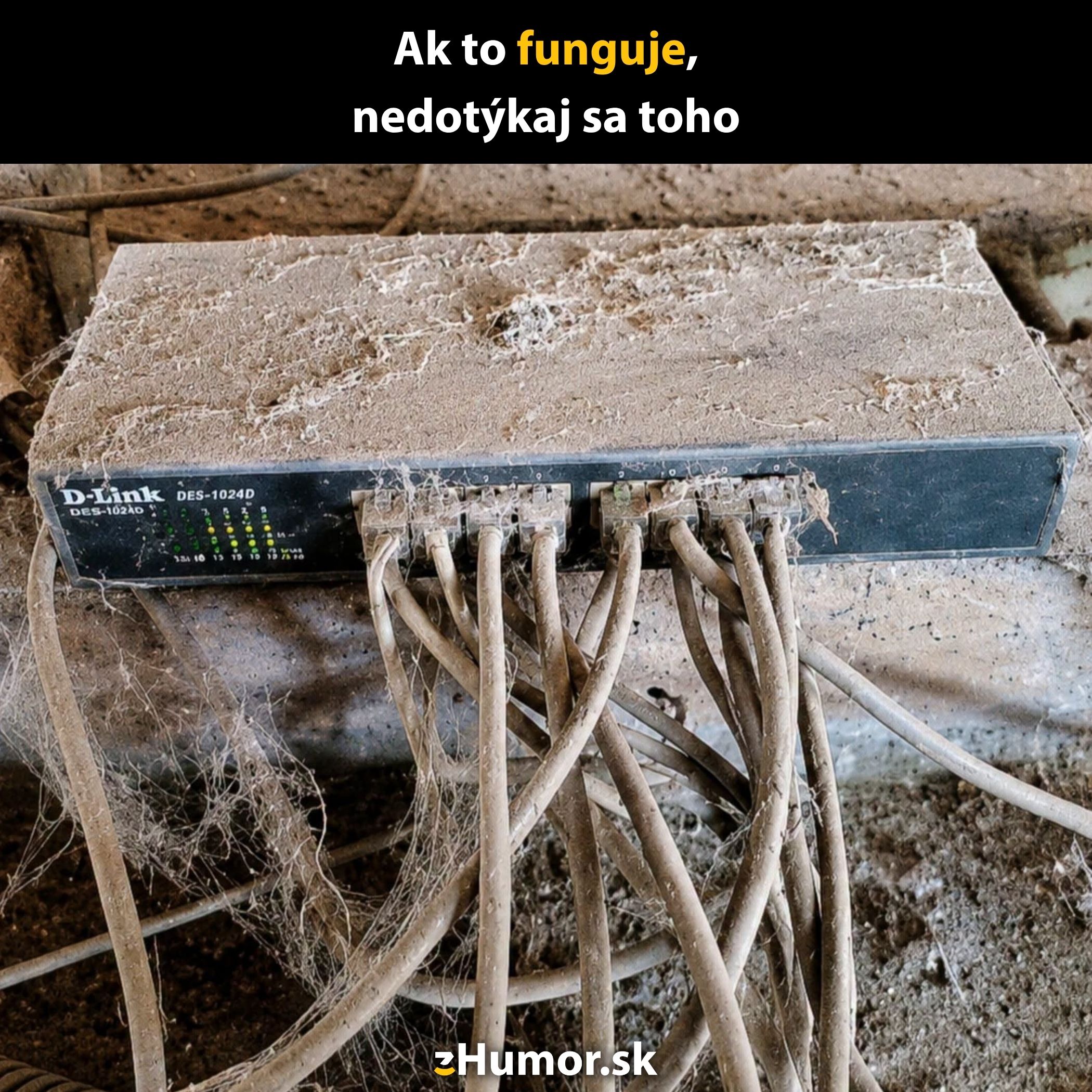 Zanesený ethernetový prepínač v prachu s upozornením: Ak to funguje, nedotýkaj sa toho.