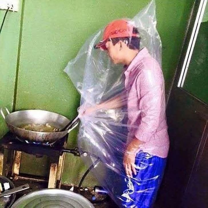 Osoba varí na panvici s použitím veľkého igelitového vreca ako ochrana pred striekajúcim olejom.