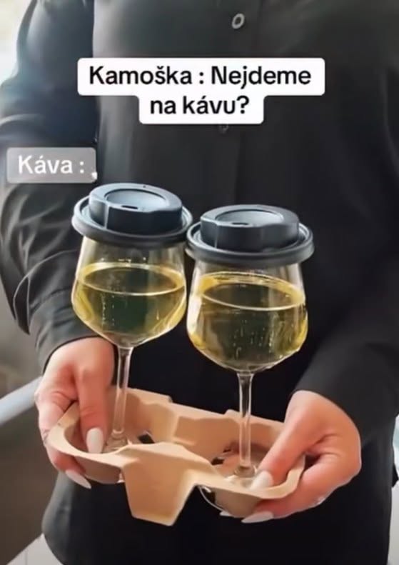 Dve poháre bieleho vína v nosiči s vrchnákmi, s nápisom Kamarádka: Nejdeme na kávu? Káva:.