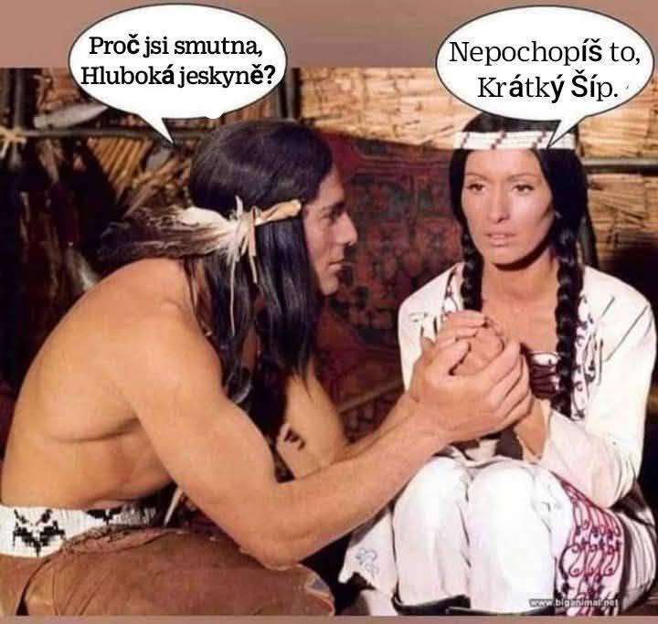 Indián s perom v hlave utešuje mladú ženu v tradičnom oblečení sediacu v stane.