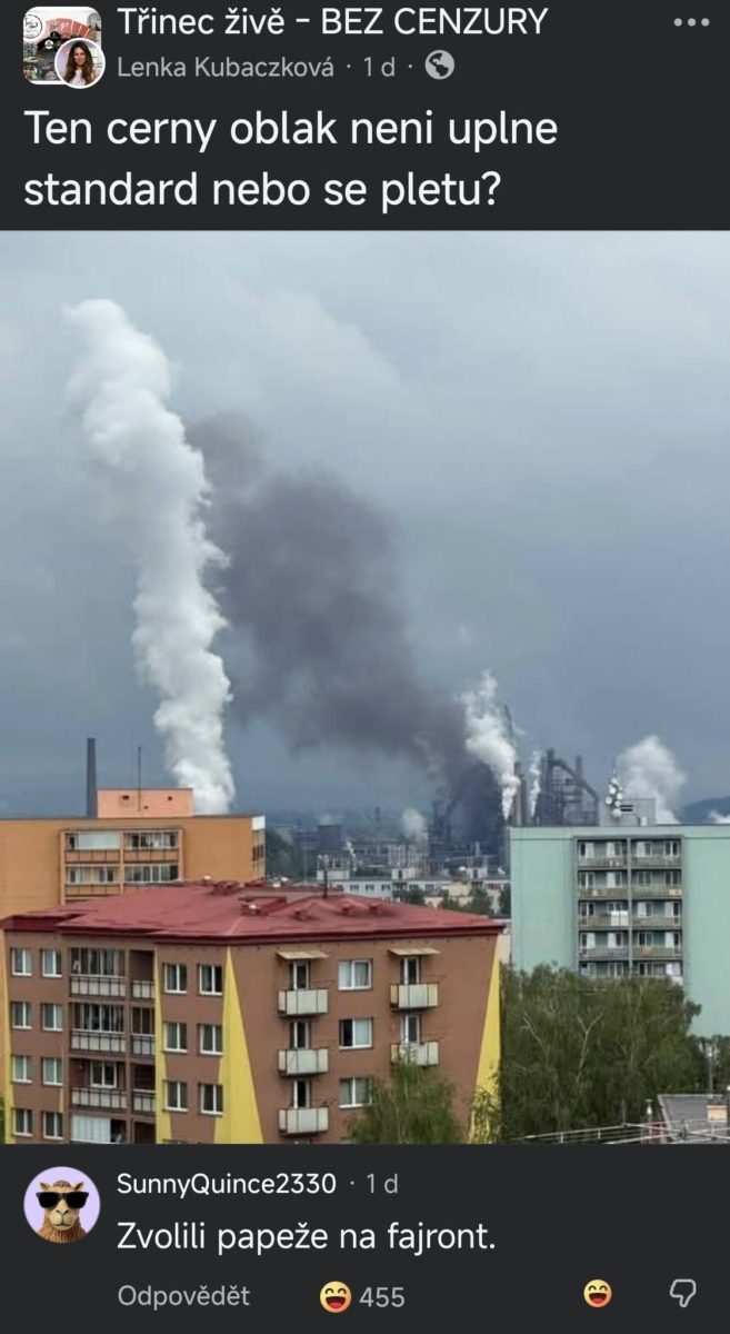 Dym nad továrňou vypúšťajúci husté oblaky nad mestom pri obytných budovách.
