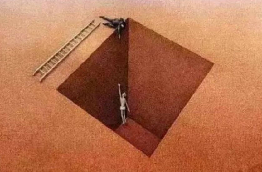 Osoba leží na okraji hlbokej jamy, kde druhá osoba visí, pričom vedľa je opretý rebrík.