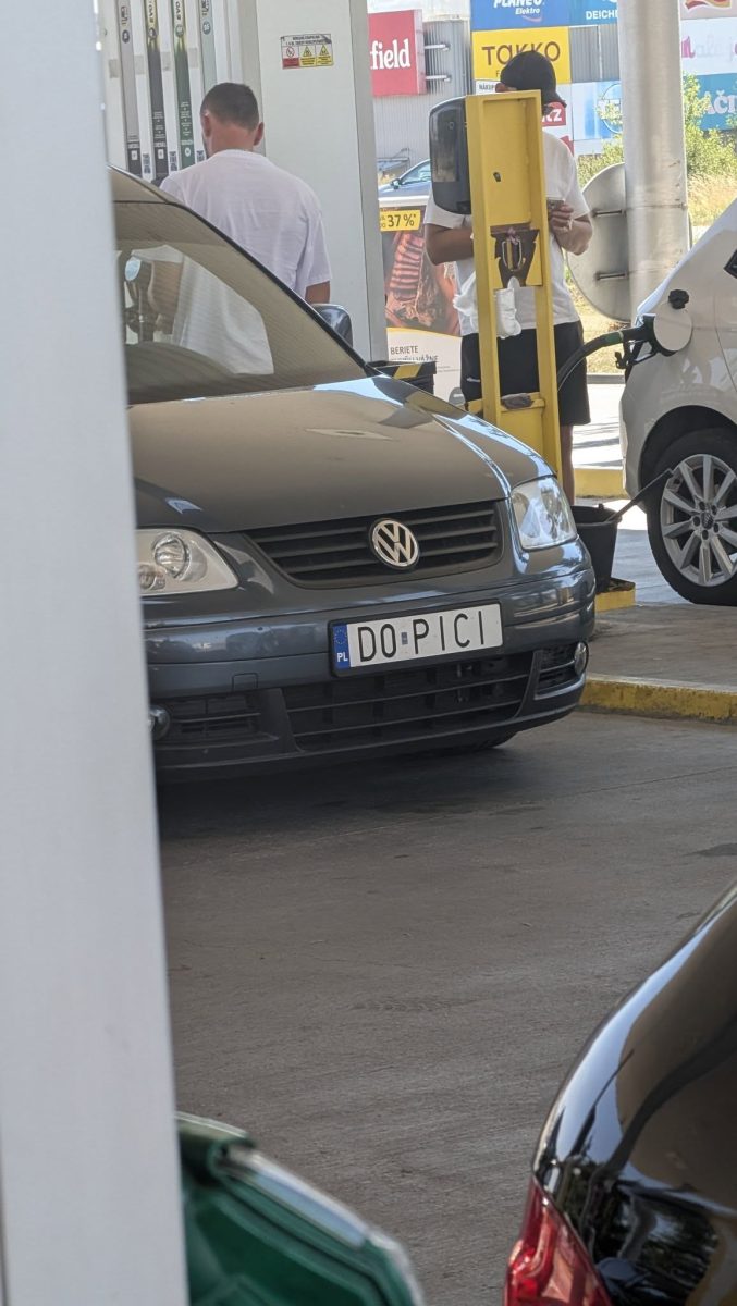 Auto s poznávacou značkou na čerpacej stanici. Ľudia tankujú palivo.