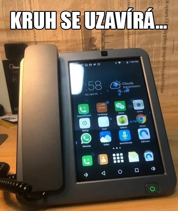 Starý telefón s moderným dotykovým displejom plným aplikácií položený na stole.