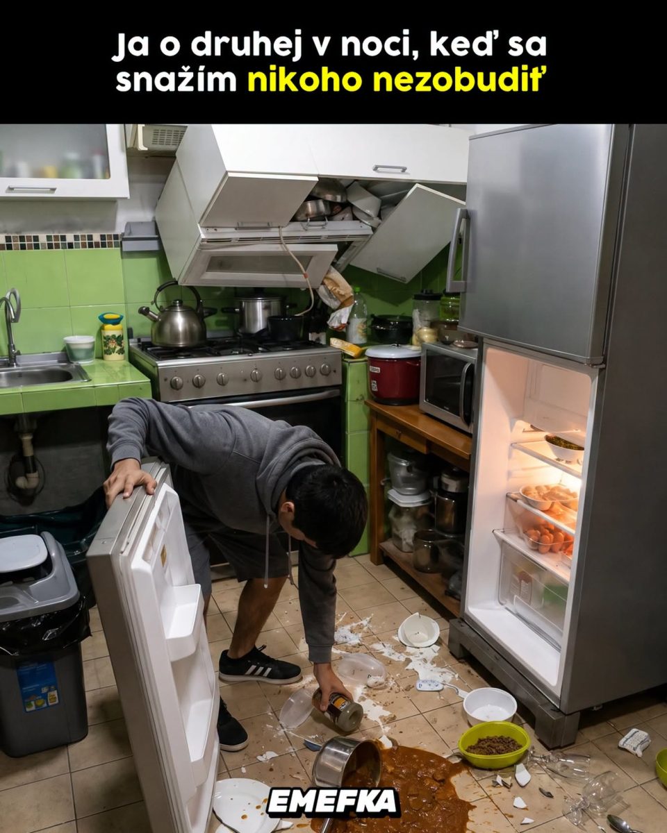 Muž v kuchyni neskoro v noci robí neporiadok a rozlieva jedlo pri otvorenej chladničke.