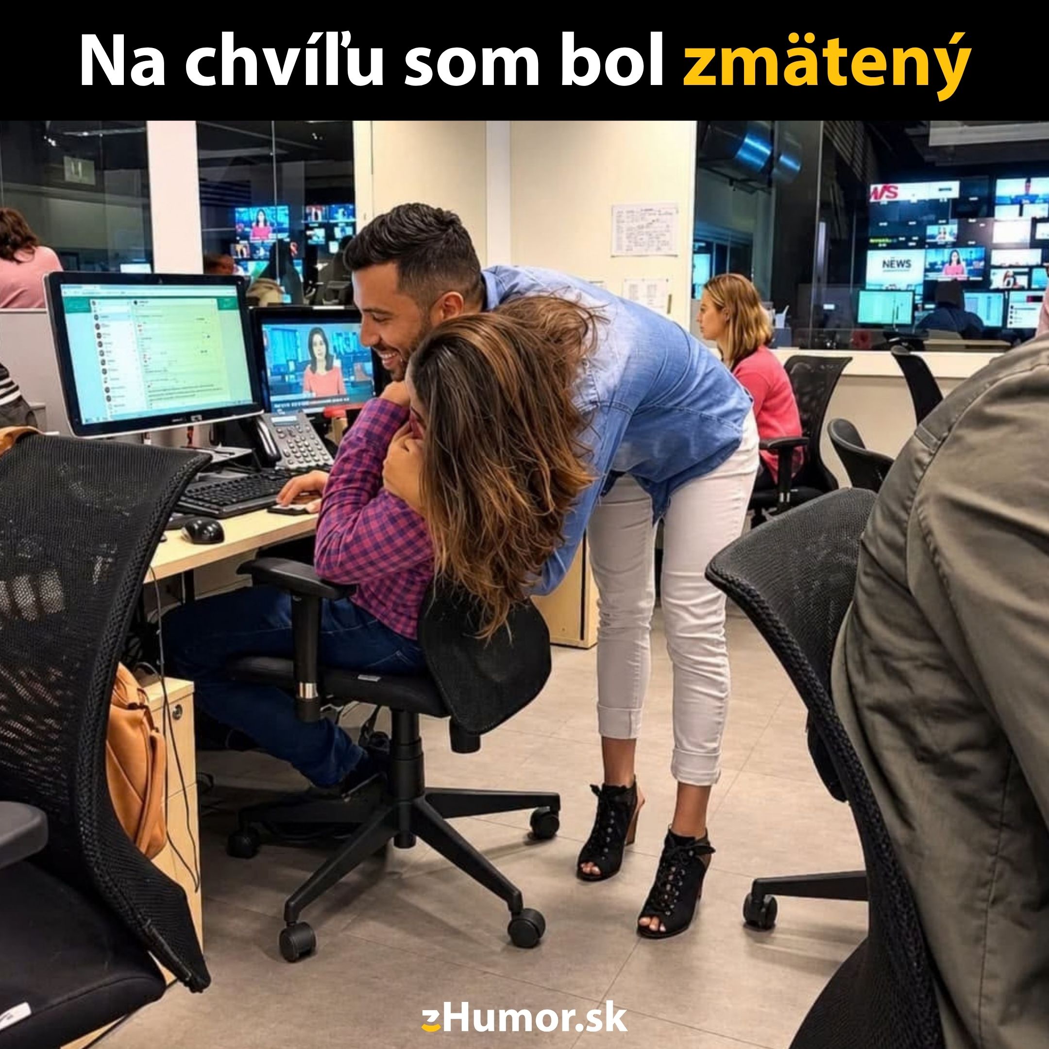 Kolegovia v kancelárii s úsmevom zdieľajú monitor počítača, moment komédie a náhleho zmätku.