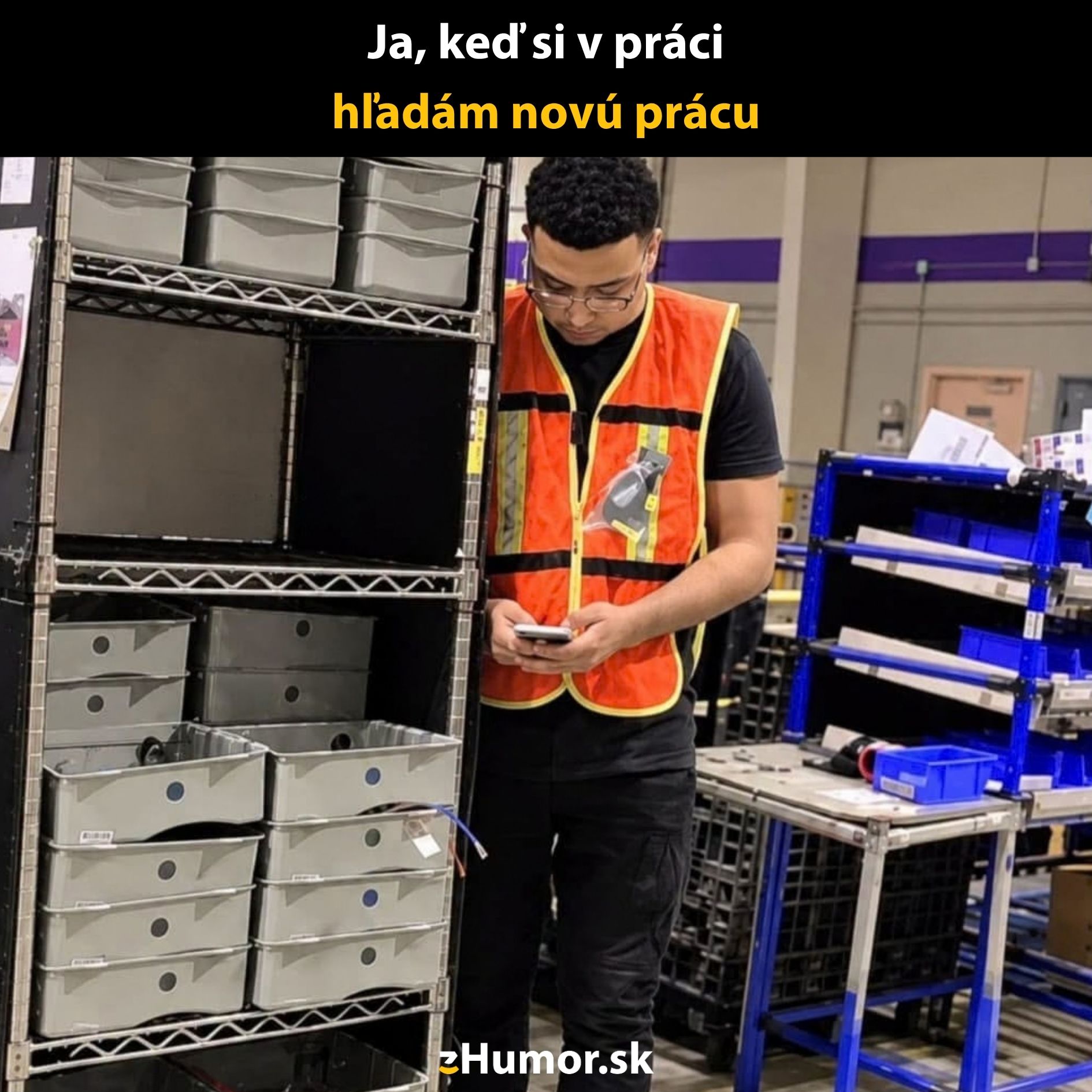 Pracovník s mobilom vo sklade, hľadá nové pracovné príležitosti počas pracovnej doby.
