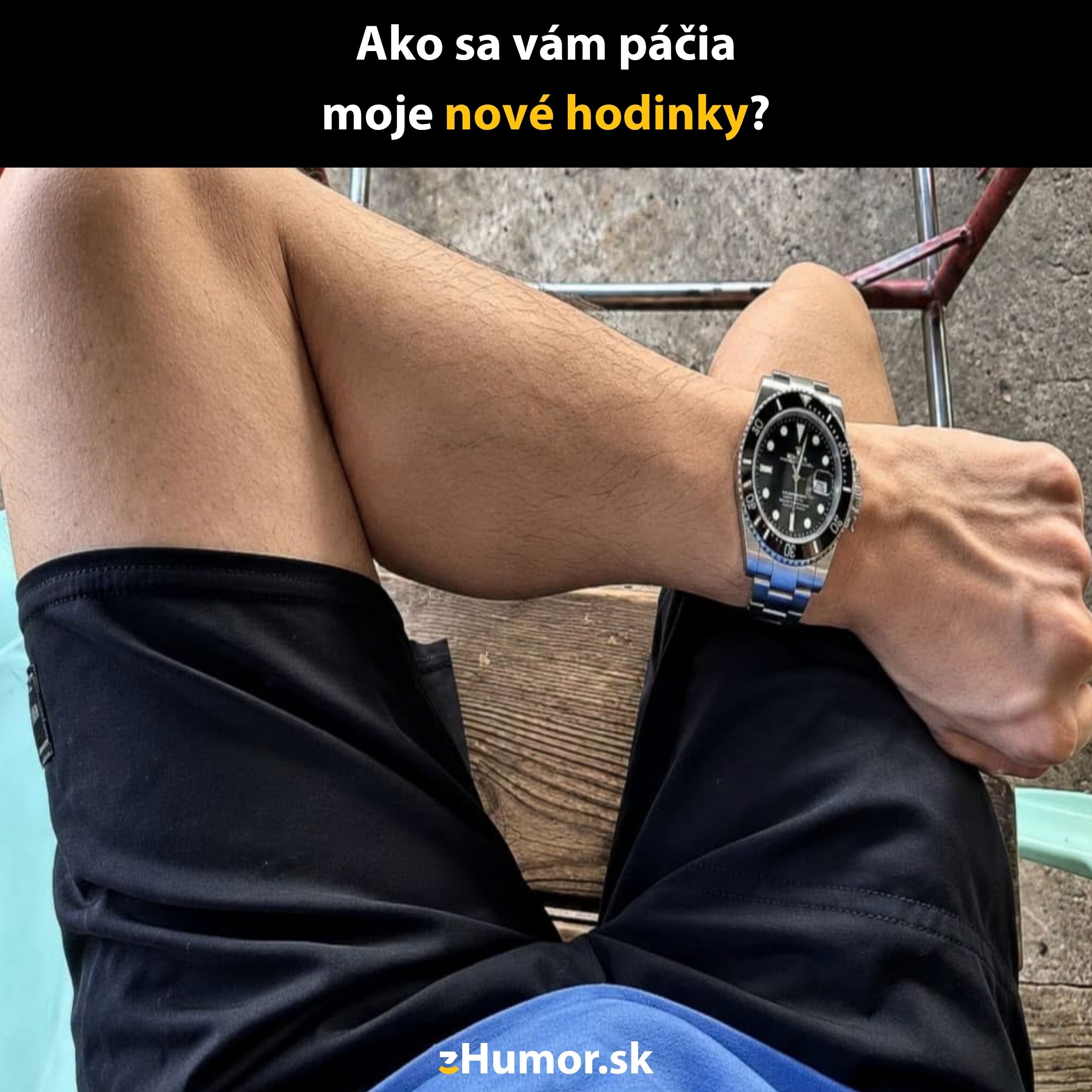 Muž sedí vonku, má na zápästí nové hodinky so strieborným pásom a čiernym ciferníkom.