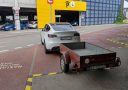 Auto s prívesným vozíkom zaparkované pri vchode do parkovacieho garáže označenej písmenom C.