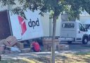Dodávka DPD vykladá balíky na chodníku; strom poskytuje tieň.