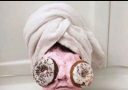 Osoba s maskou z ružového hustého krému a donutmi na očiach, vtipný pohľad na diétu.